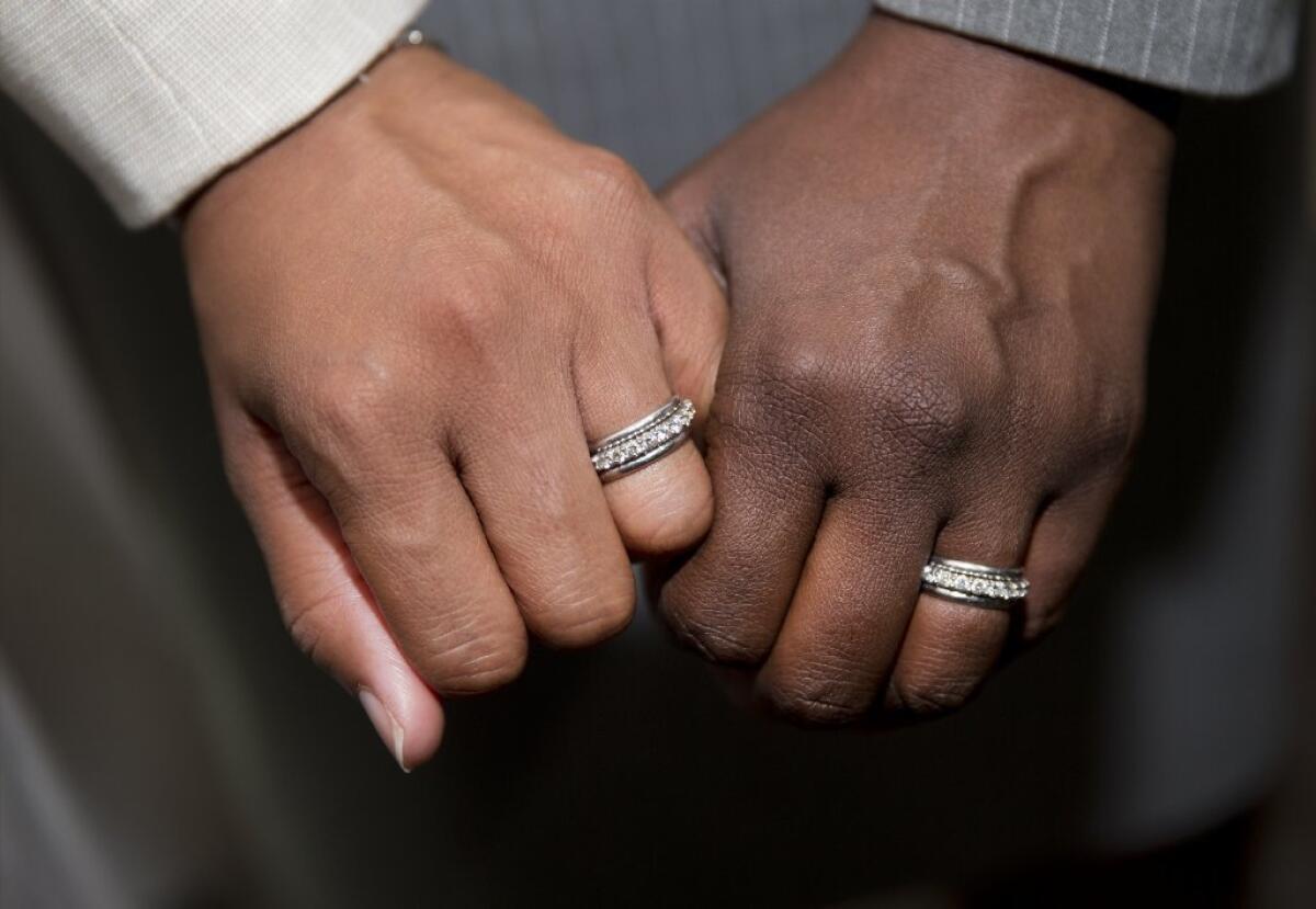 Emma Foulkes, left, and Petrina Bloodworth hold hands and show their wedding rings after being married at the Foulton County Courthouse Friday, June 26, 2015, in Atlanta. A court in Atlanta has started marrying gay couples after the U.S. Supreme Court struck down Georgia's ban on same-sex marriage.