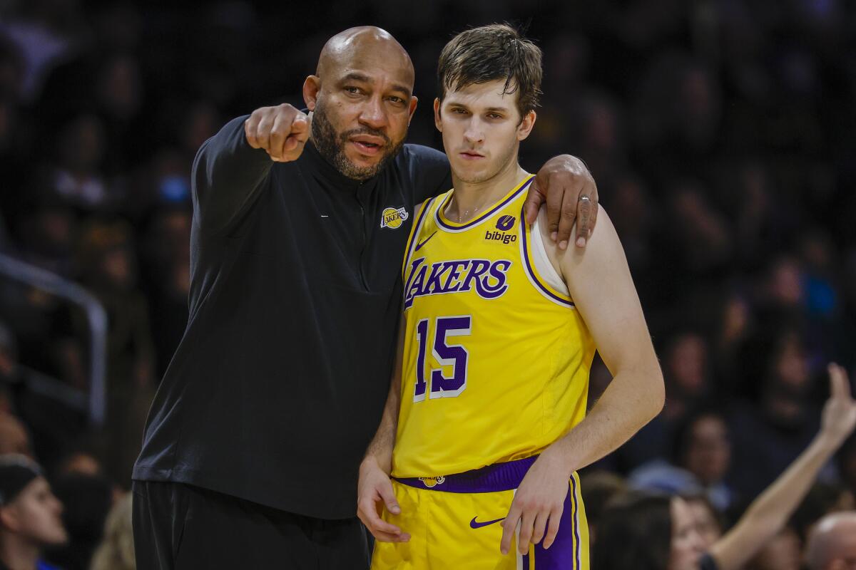 Lakers coach Darvin Ham speaks to guard Austin Reaves during a game against the Charlotte Hornets in December.