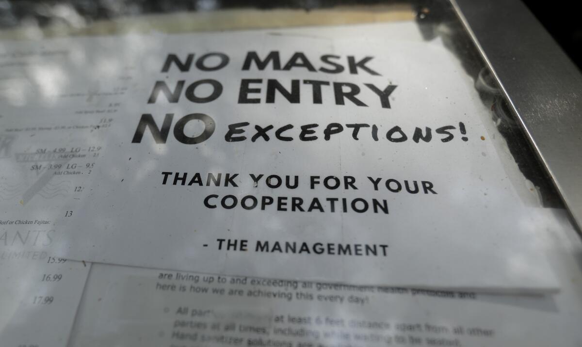 Un restaurante avisa en una puerta que no se permitirá la entrada a clientes que no lleven puesta mascarilla en Texas.