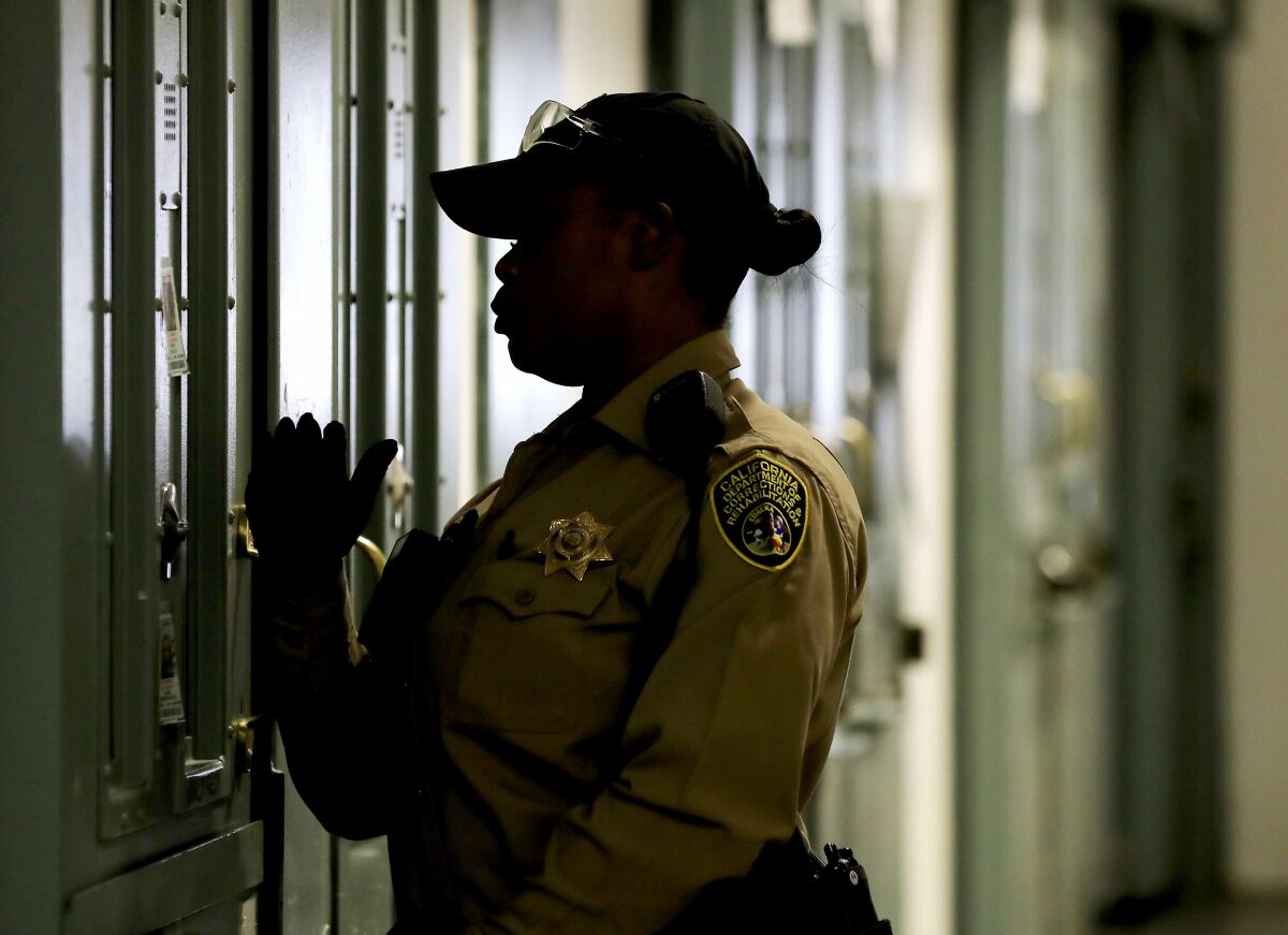 A prison guard checks on inmates at California State Prison, Sacramento. 