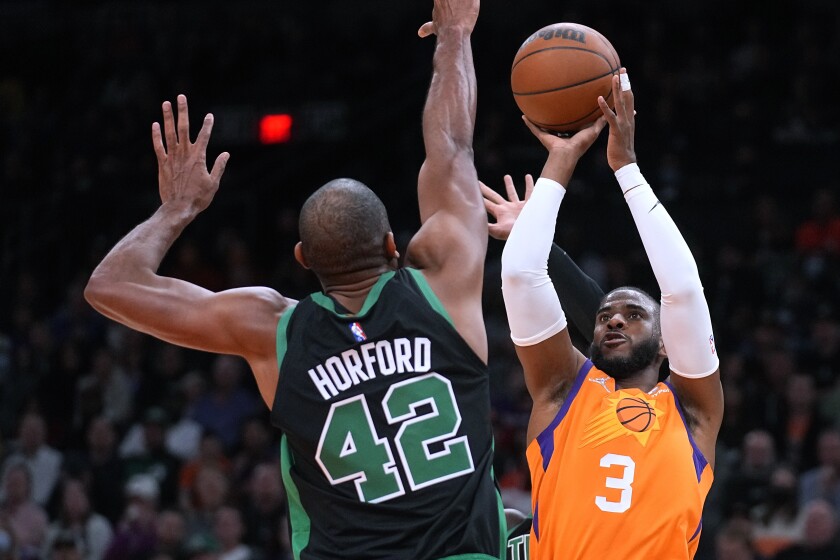 Phoenix Suns guard Chris Paul shoots over Boston Celtics center Al Horford during the first half of an NBA basketball game Friday, Dec. 10, 2021, in Phoenix. (AP Photo/Rick Scuteri)