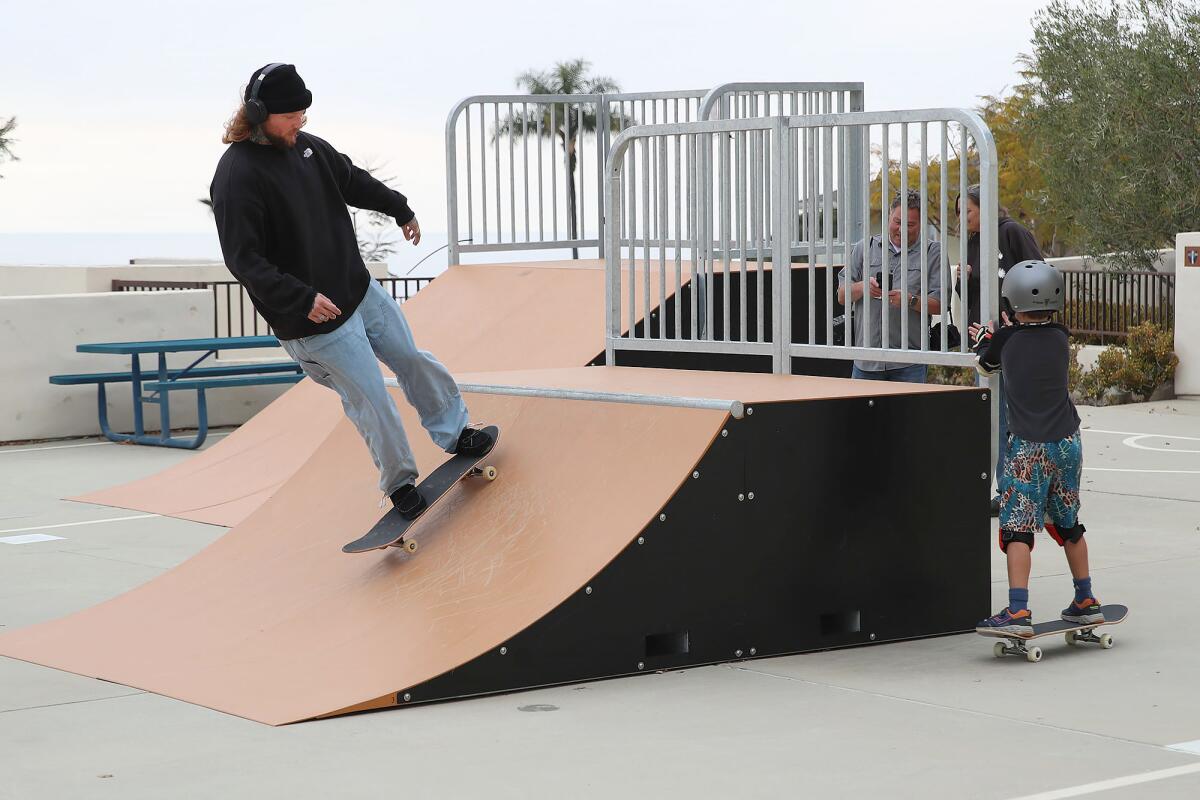 Skateboarders Jake Morel and 8-year-old Taylor Marriner, from left, test the new skate ramps.