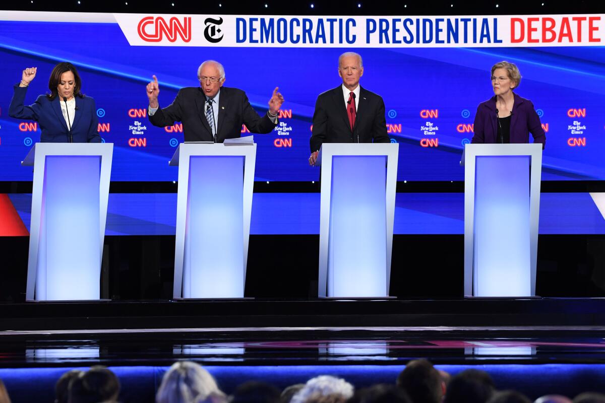 Democratic presidential hopefuls Kamala Harris, left, Bernie Sanders, Joe Biden and Elizabeth Warren on stage in a debate.