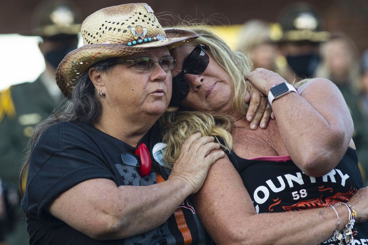 Route 91 Harvest festival shooting survivors Sue Ann Cornwell, left, of North Las Vegas, and Alicia Mierke of Henderson attend the annual 1 October Remembrance Ceremony at the Clark County Government Center on Friday, Oct. 1, 2021, in Las Vegas. (Bizuayehu Tesfaye/Las Vegas Review-Journal via AP)