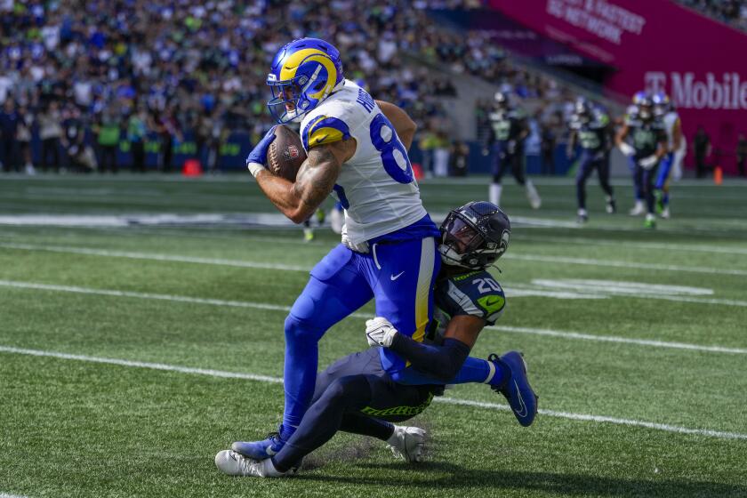 Los Angeles Rams tight end Tyler Higbee is tackled by Seattle Seahawks safety Julian Love during the second half of an NFL football game Sunday, Sept. 10, 2023, in Seattle. (AP Photo/Stephen Brashear)