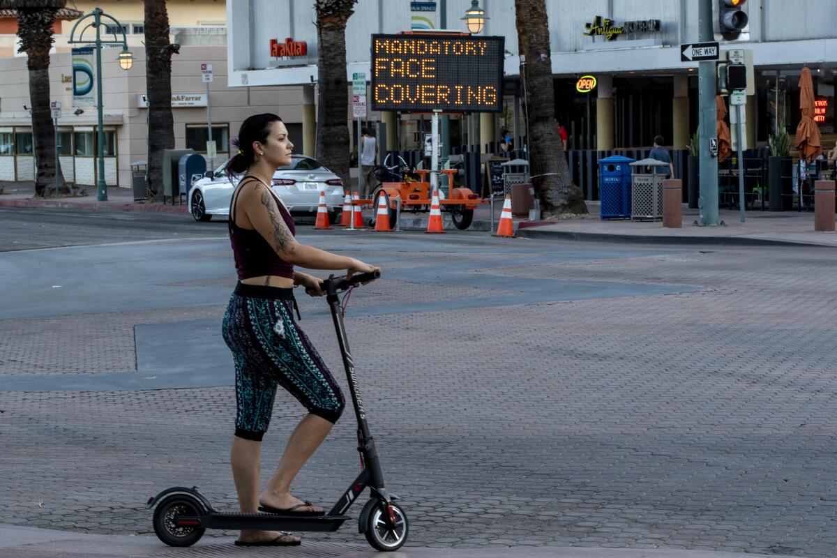 A woman travels on a scooter in downtown Palm Springs
