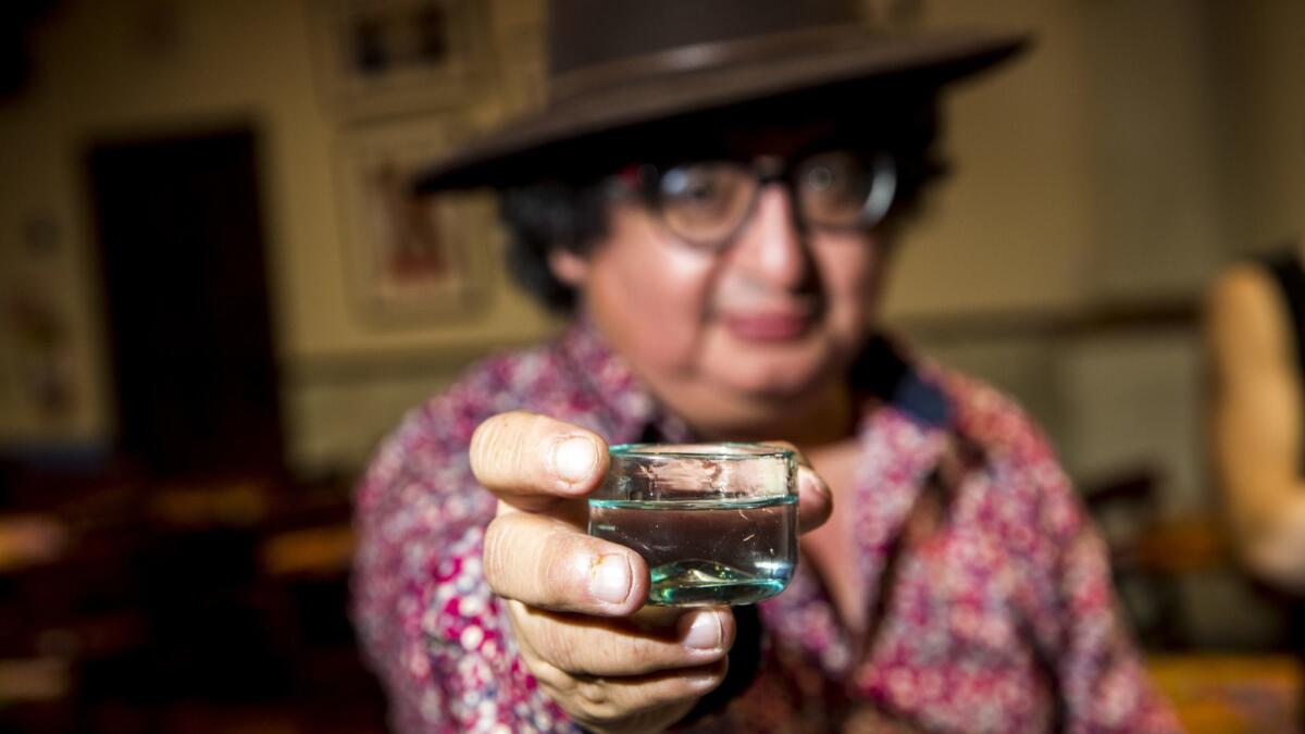 Ulises Torrentera holds up a glass of mezcal at Guelaguetza.