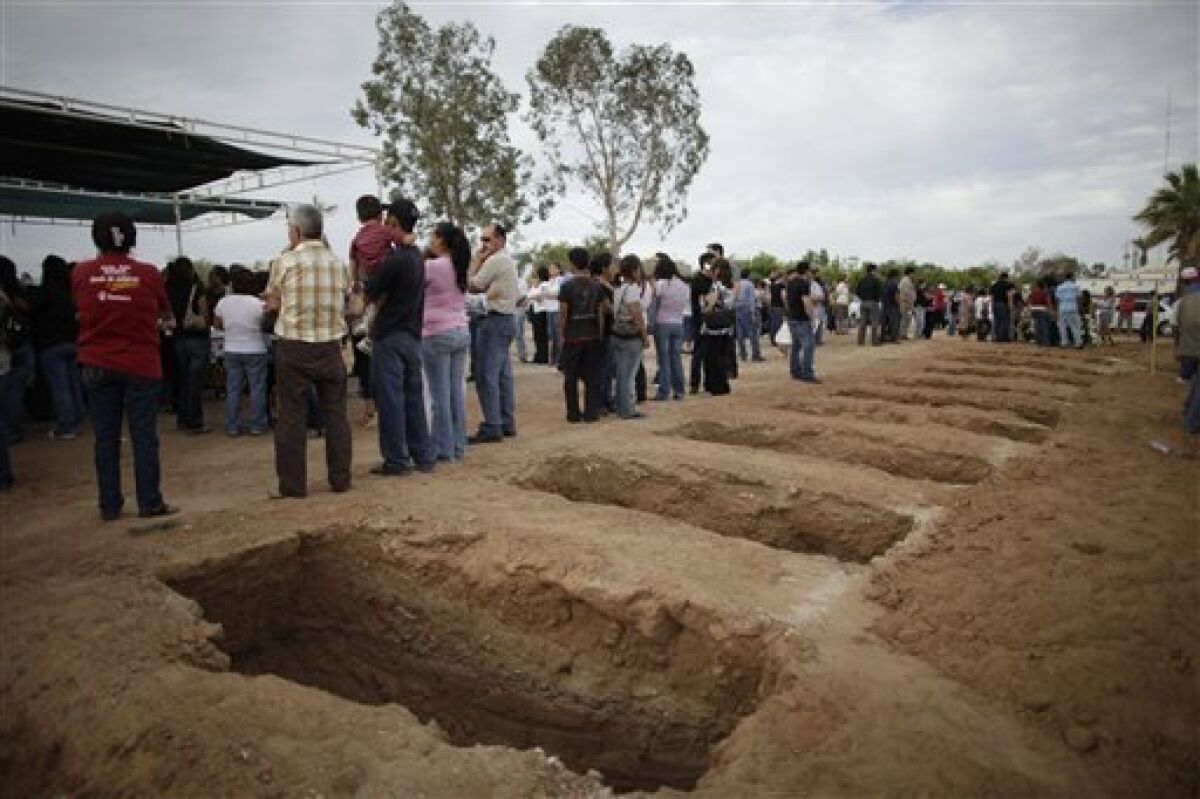 Newly dug graves for children killed during a fire in a day care center are seen at a cemetery in Hermosillo, Mexico, Saturday, June 6, 2009. A fire killed 38 children in the day care center in northern Mexico despite desperate attempts of firefighters and a father who crashed his pickup truck through the wall to rescue babies, toddlers and others trapped inside. (AP Photo/Alexandre Meneghini)