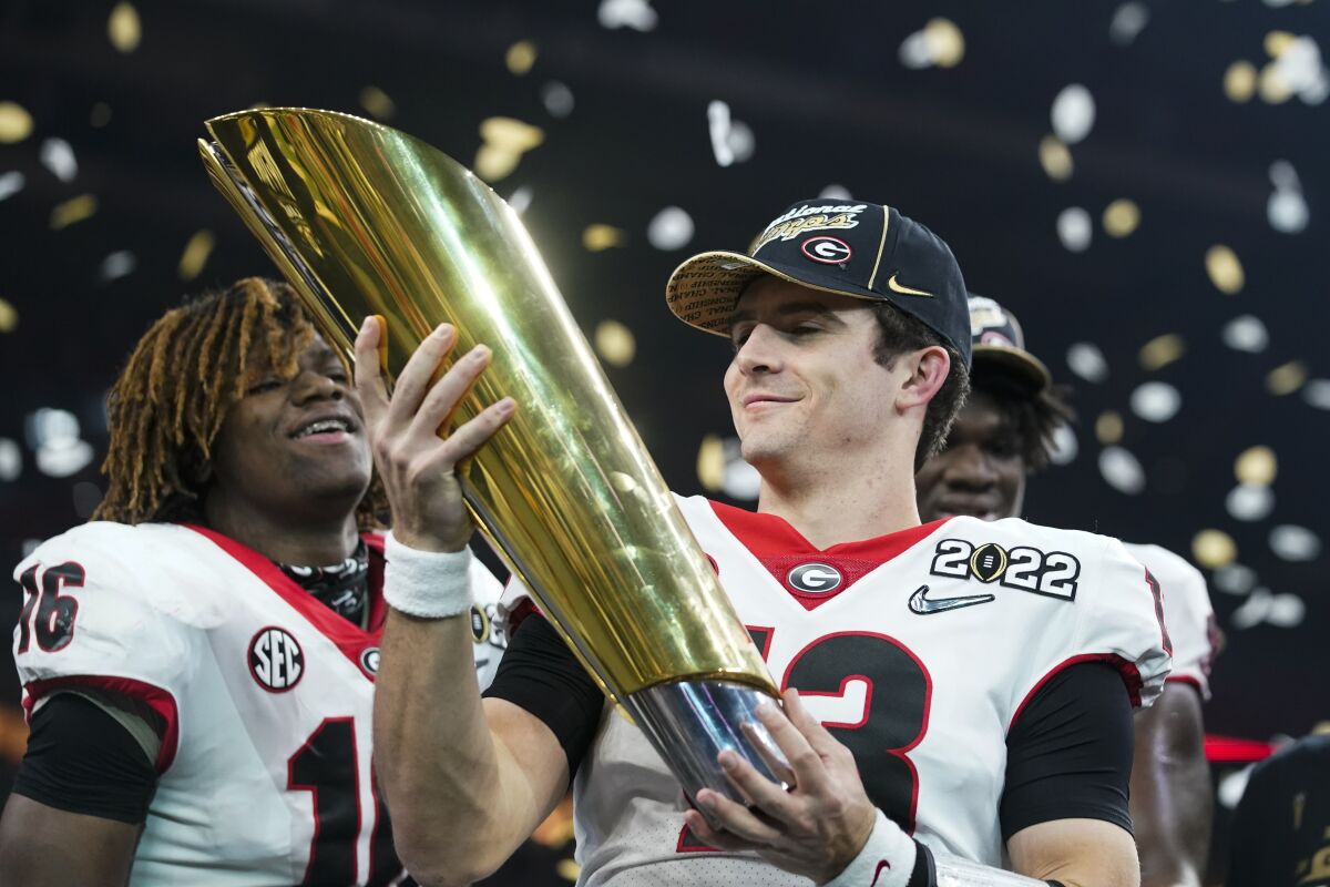 Georgia quarterback Stetson Bennett celebrates with the College Football Playoff national championship trophy.