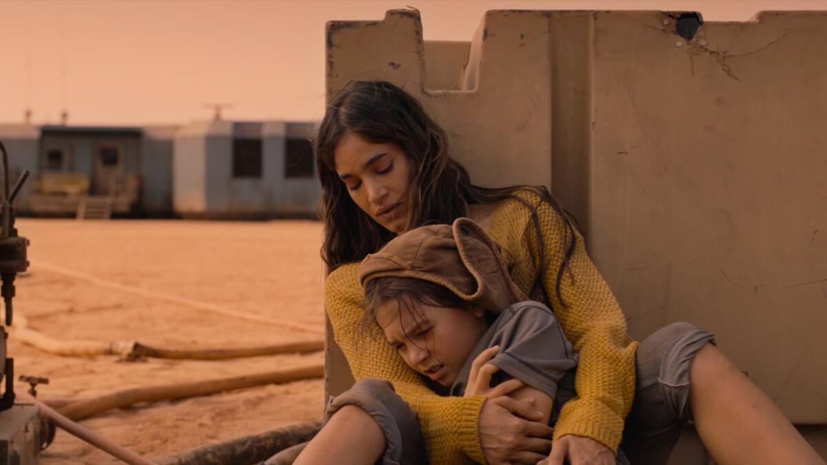 A mother holds her young daughter in the movie “Settlers”