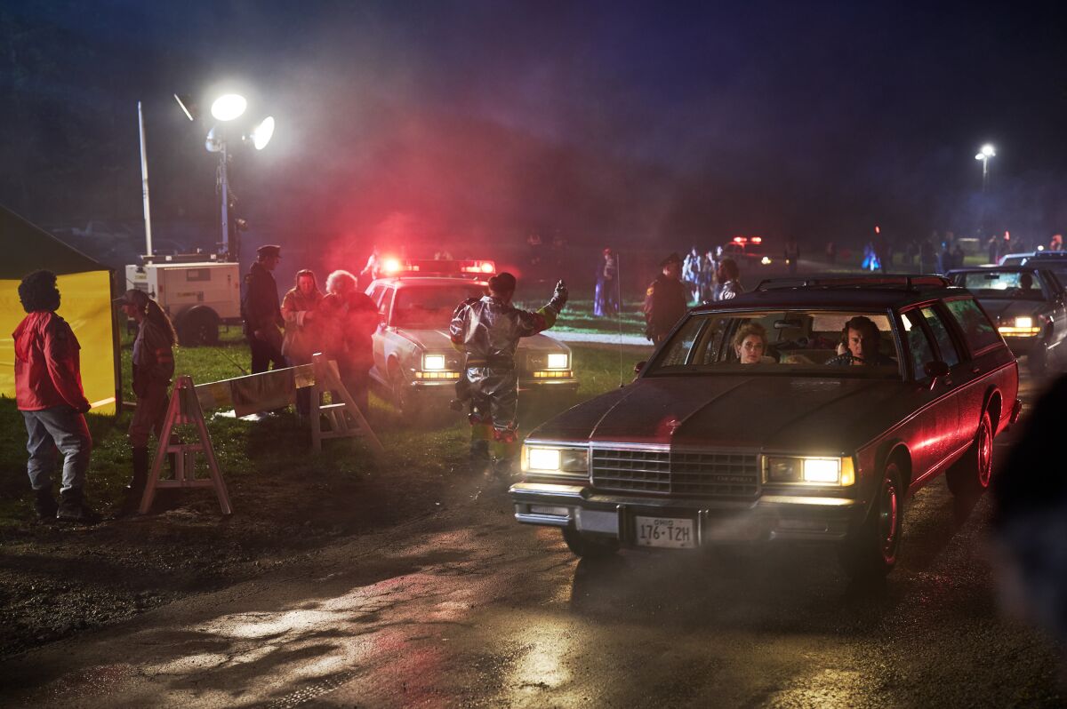 A family in a station wagon with chaos around them