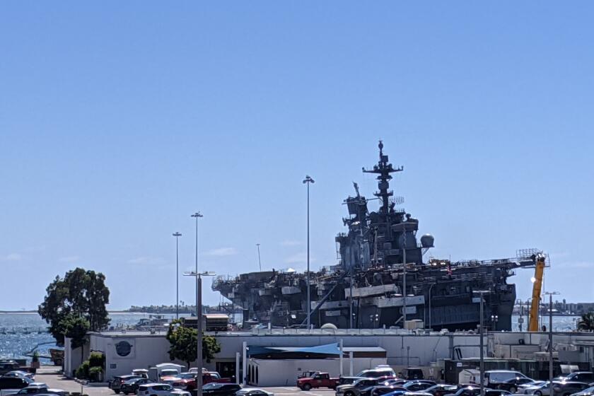 The amphibious assault ship Bonhomme Richard (LHD-6) lists to its port side Thursday as the Navy reports all fires on board have been extinguished. The ship burned more than four days.