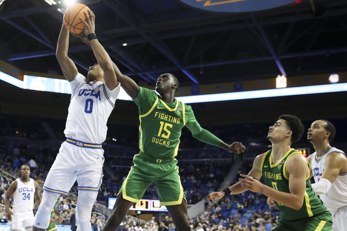 UCLA Bruins guard Jaylen Clark and Oregon Ducks forward Lok Wur battle for a rebound during the second half.