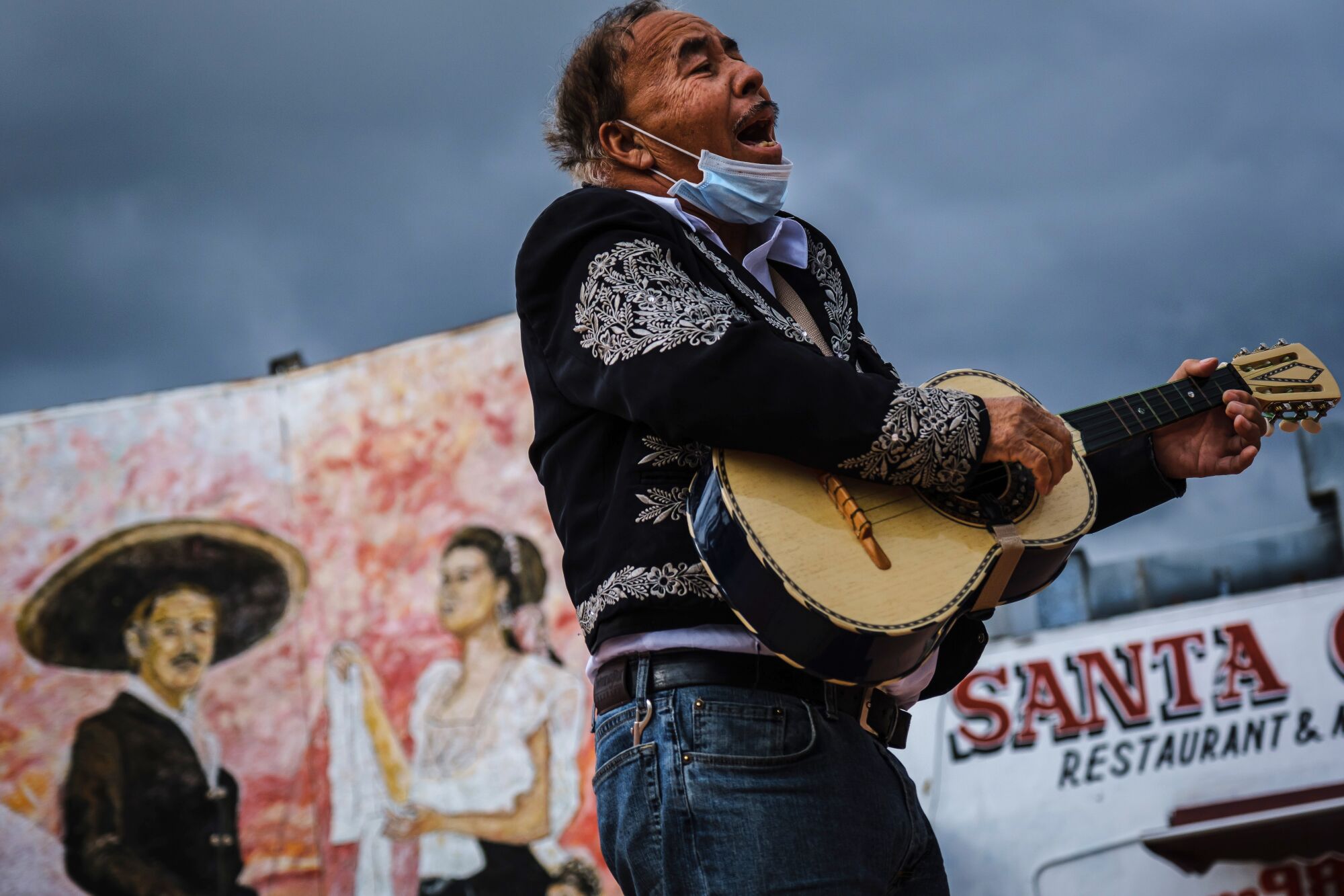 Santos Monge serenades amid an empty space with his vihuela (a small guitar) as he awaits work as a musician at Mariachi Plaza in Los Angeles.