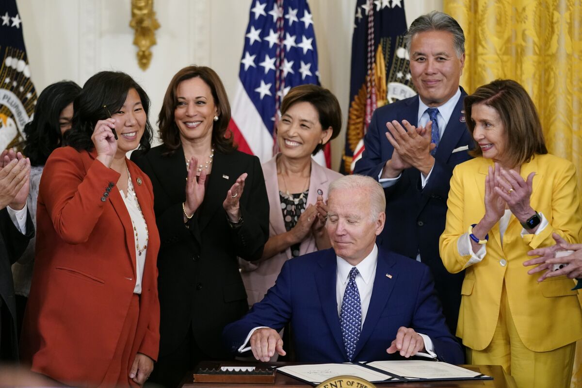 Rep. Grace Meng, D-N.Y., holds up a pen given to her by President Joe Biden during a bill signing ceremony for the "Commission To Study the Potential Creation of a National Museum of Asian Pacific American History and Culture Act," Monday, June 13, 2022, in the East Room of the White House in Washington. Also on stage are Vice President Kamala Harris, second from left, Rep. Young Kim, R-Calif., Rep. Mark Takano, D-Calif., and House Speaker Nancy Pelosi of Calif. (AP Photo/Patrick Semansky)
