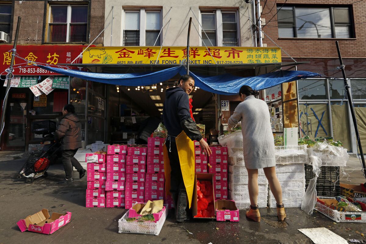 Workers at Kim Fong Market on 8th Avenue in Sunset Park unpack bags of grapes, which cost $1 per bag. Changes along the neighborhood's waterfront haven't yet reached its Chinatown.