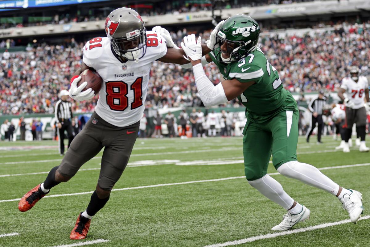 New York Jets cornerback Bryce Hall, right, tackles Tampa Bay Buccaneers wide receiver Antonio Brown.