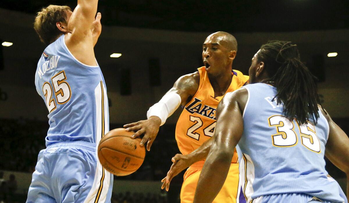 Lakers guard Kobe Bryant makes a pass around Nuggets center Timofey Mozgov (25) during the first half of their exhibition game Monday in San Diego.