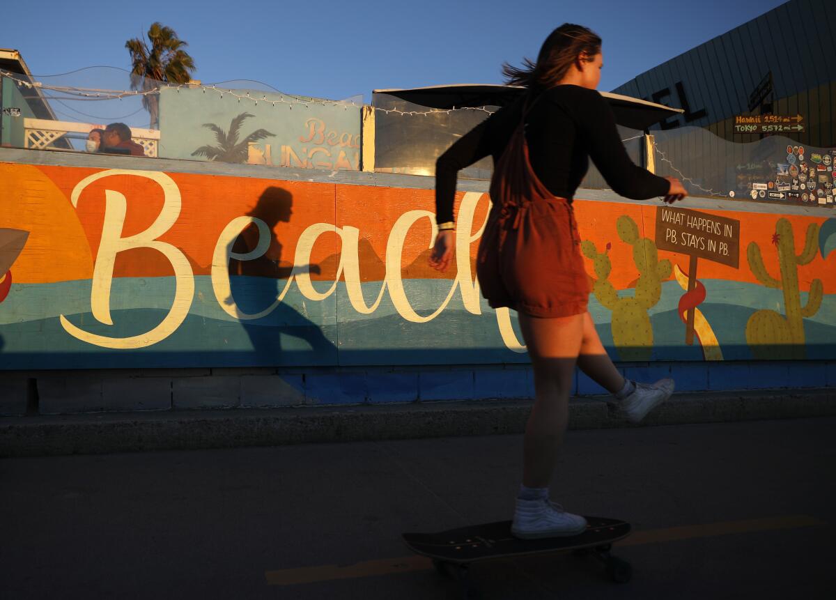 A woman skateboards along the Pacific Beach boardwalk on Sunday, Dec. 20, 2020 in San Diego.