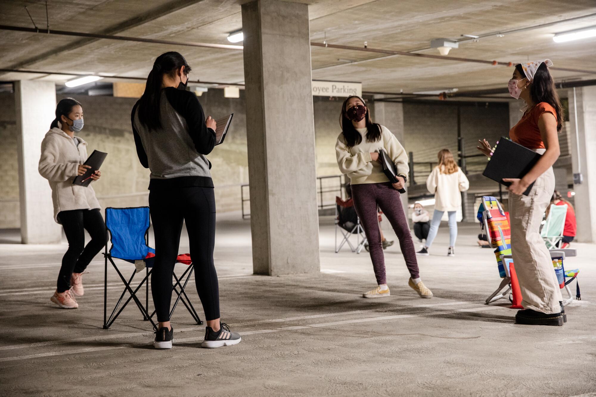 Vishaala Wilkinson, right, talks with fellow choristers of San Diego Children’s Choir in a parking garage