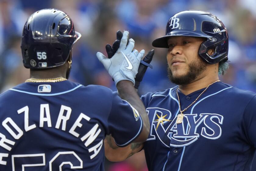 Tampa Bay Rays' Harold Ramirez, right, celebrates with teammate Randy Arozarena, left, after hitting a home run and also driving in Arozarena during fifth-inning baseball game action against the Toronto Blue Jays in Toronto, Saturday, Sept. 30, 2023. (Frank Gunn/The Canadian Press via AP)