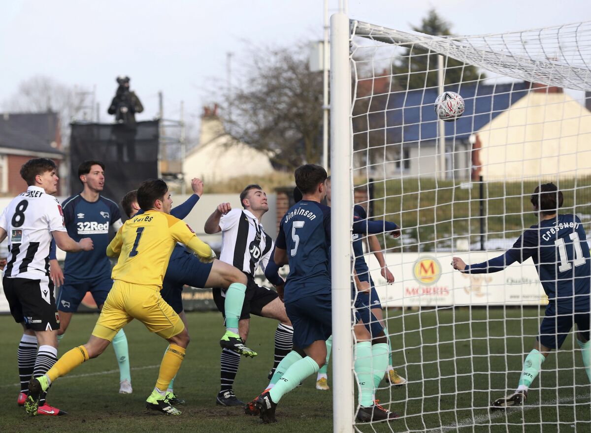 Chorley's Connor Hall, black and white strip at centre, scores his side's first goal of the game against Derby County, during the English FA Cup third round match at Victory Park in Chorley, England, Saturday Jan. 9, 2021. (Martin Rickett/PA via AP)