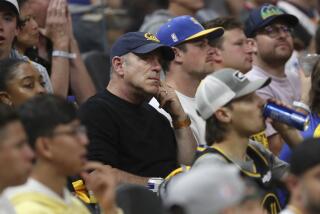 Oakland Athletics owner John Fisher, center, watches Game 2 of the NBA Finals in San Francisco on June 5, 2022.