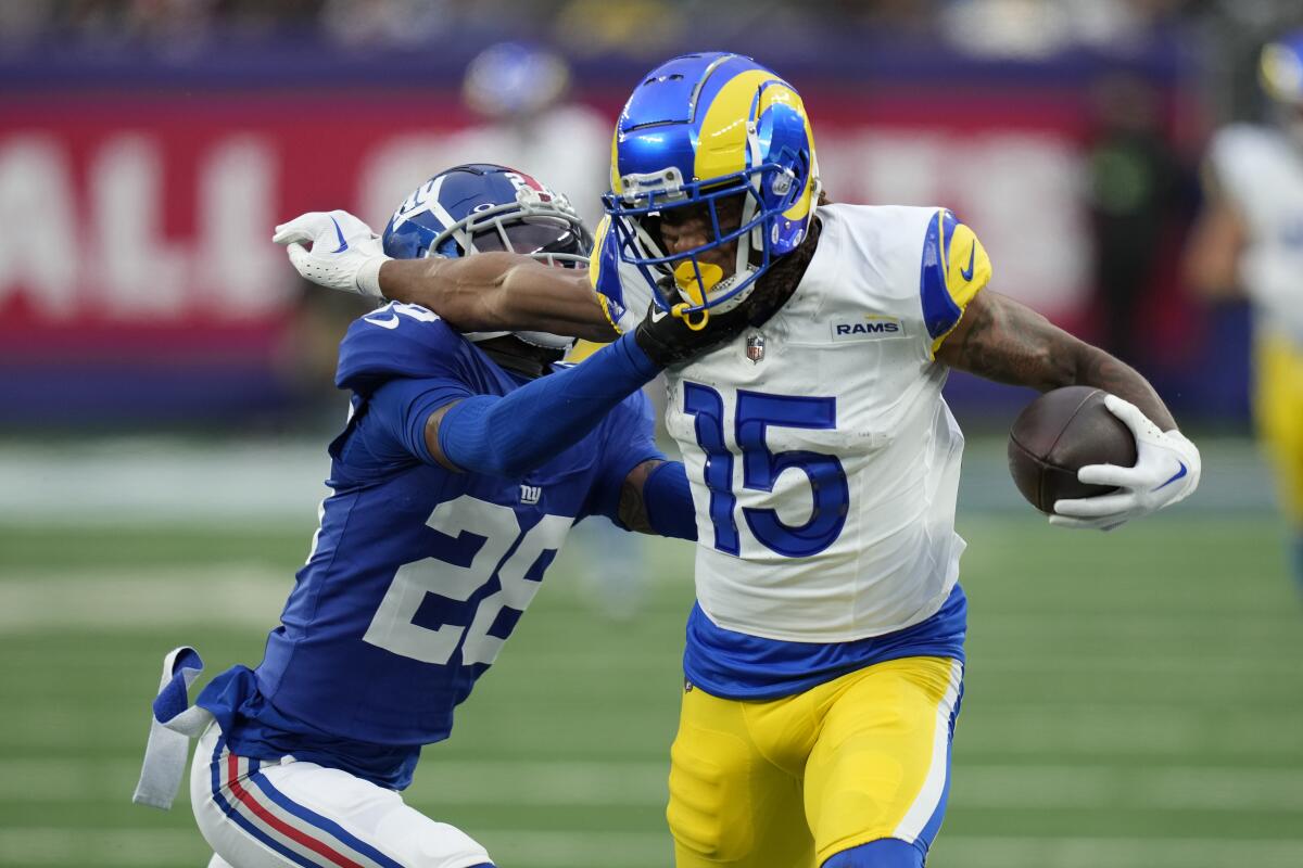 Rams'ın geniş alıcısı Demarcus Robinson, sağda, New York Giants'ın korner oyuncusu Cor'Dale Flott'a sert bir şekilde saldırmaya çalışıyor.