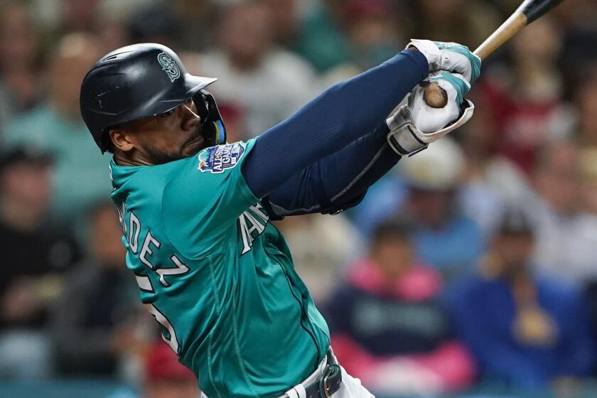 Seattle Mariners' Teoscar Hernandez follows through in a baseball game against the Los Angeles Angels.