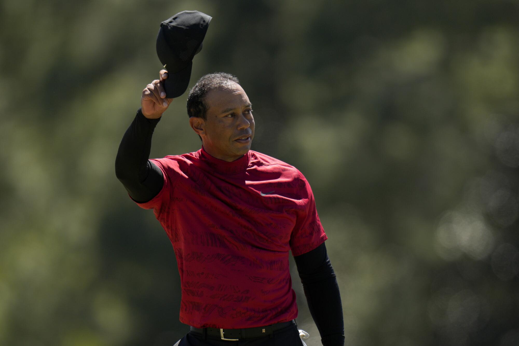 Tiger Woods tips his cap on the 18th green during the final round.