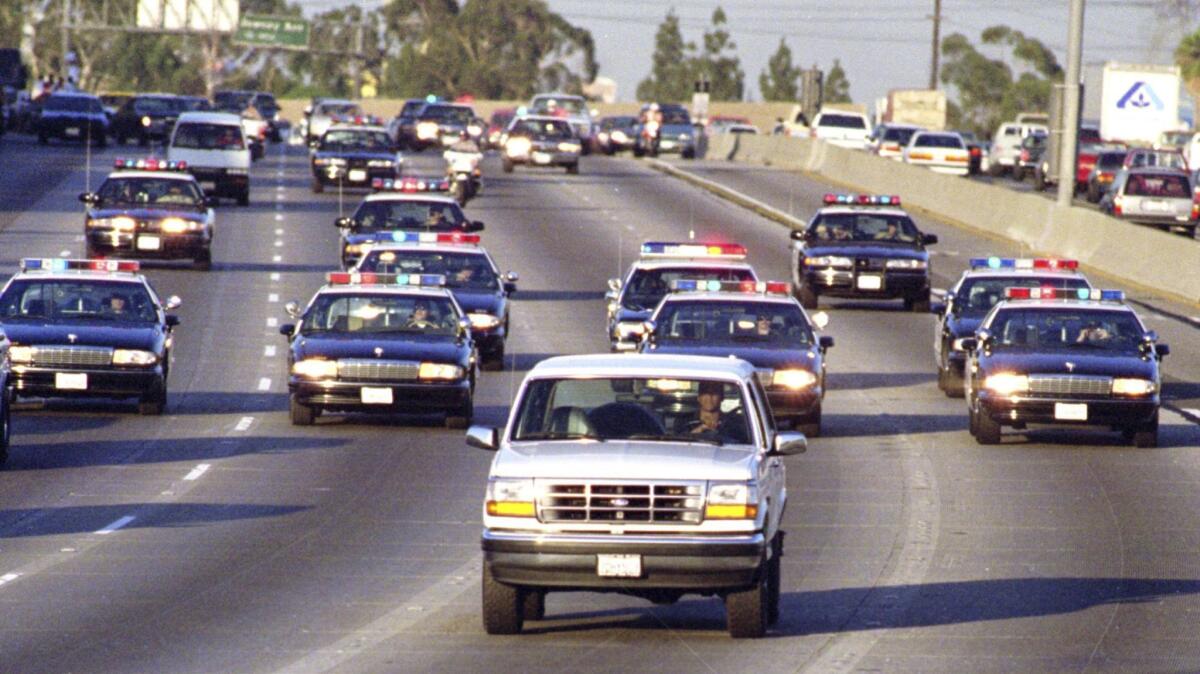 California Highway Patrol cars pursue the white Bronco driven by Al Cowlings as O.J. Simpson hides in the back of the vehicle on June 17, 1994.