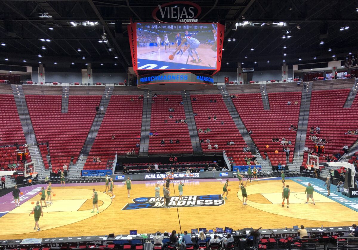 A smattering of fans keep one eye on Wright State practice at Viejas Arena and one eye on SDSU-Creighton game on video board.