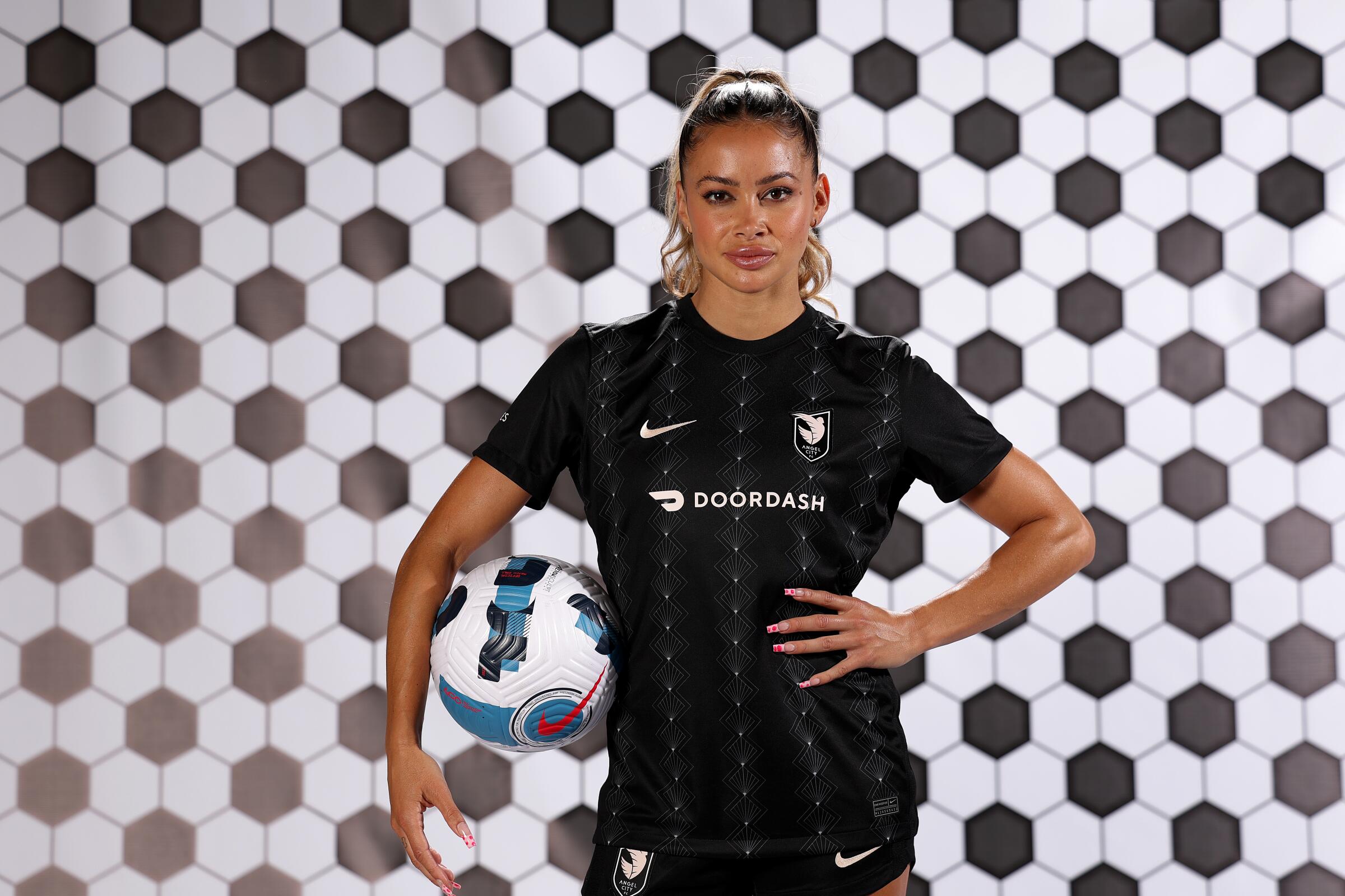 Angel City FC defender Sarah Gorden poses for a portrait while holding a soccer ball.