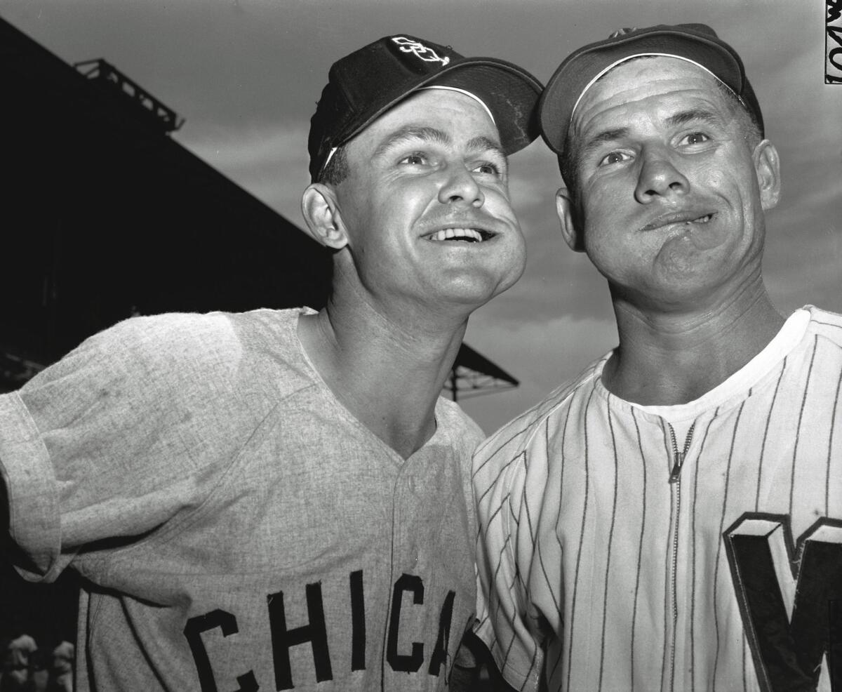Chicago White Sox second baseman Nellie Fox, left, and Washington Senators shortstop Rocky Bridges pose with bulging wads of chewing tobacco in their cheeks before a game at Washington on Aug. 1, 1957.