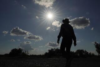 Kayak and canoe outfitter Jessie Fuentes walks along the Rio Grande under a warm sun Thursday, July 6, 2023. (AP Photo/Eric Gay)
