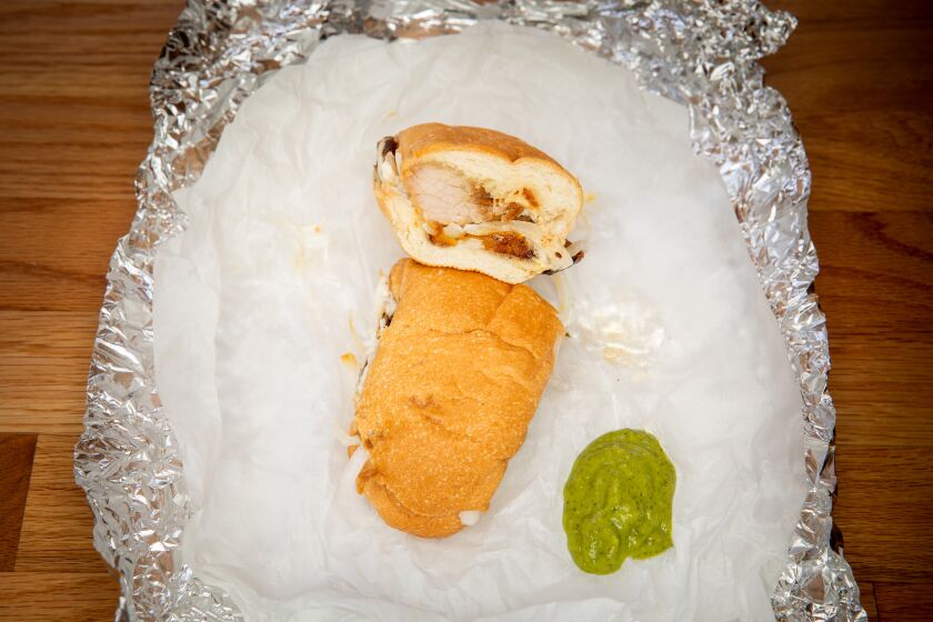 LOS ANGELES, CA - AUGUST 28: A fried pork sandwich, to-go, with green sauce made of cilantro, jalapenos, garlic, lime juice, avocado, olive oil and salt and pepper, photographed at a Los Angeles, CA, home, Friday, Aug. 28, 2020. (Jay L. Clendenin / Los Angeles Times)