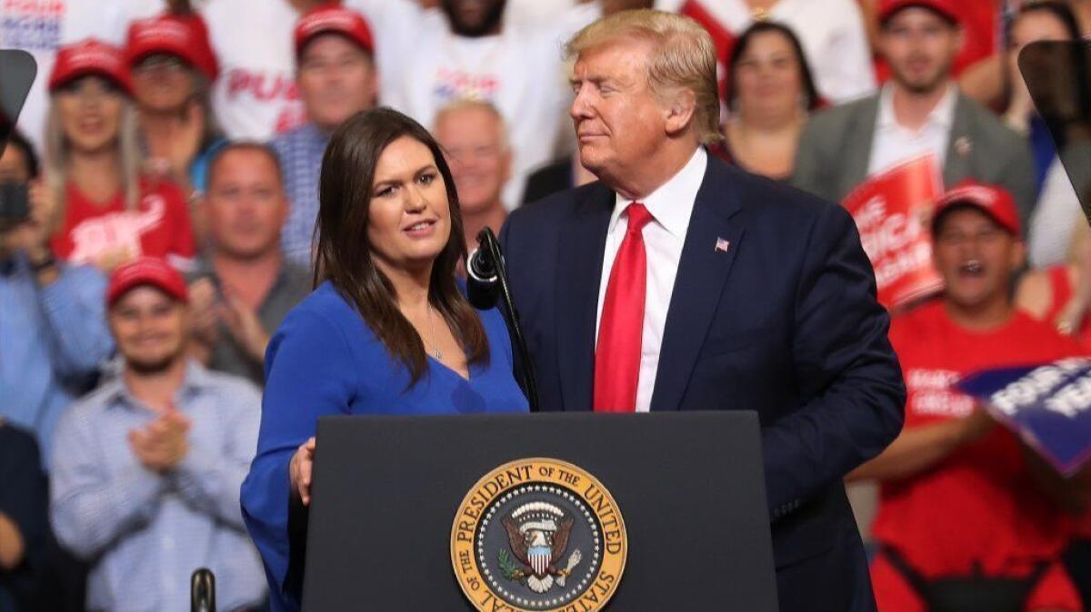 President Trump stands with Sarah Huckabee Sanders, during a rally in Orlando, Fla., where he announced his candidacy for a second presidential term. Sanders has stepped down as White House press secretary.