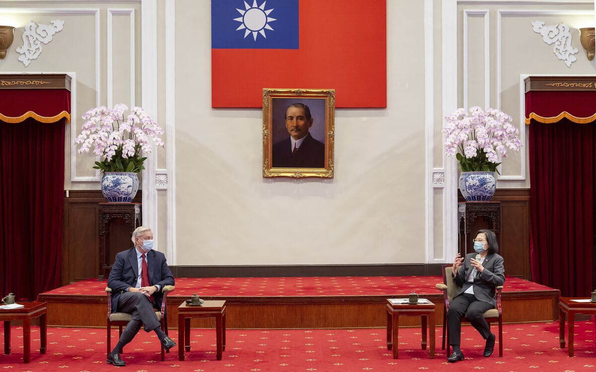In this photo released by the Taiwan Presidential Office, Sen. Lindsey Graham, R-S.C., left, listens as Taiwan's President Tsai Ing-wen, right, speaks during a meeting at the Presidential Office in Taipei, Taiwan, Friday, April 15, 2022. U.S. lawmakers visiting Taiwan have made a pointed and public declaration of their support for the self-governing island democracy while also issuing a warning to China. (Taiwan Presidential Office via AP)