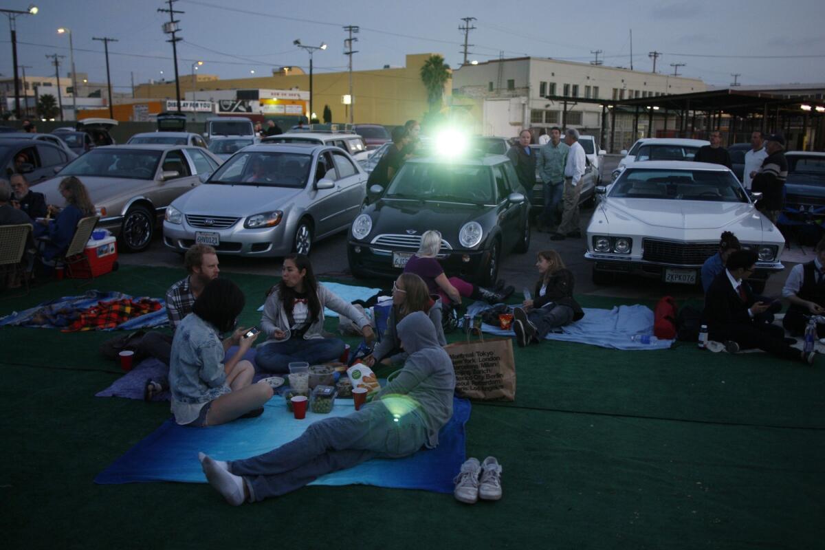 Park your car and settle in among the downtown skyscrapers at Electric Dusk Drive-In, car hops and all.
