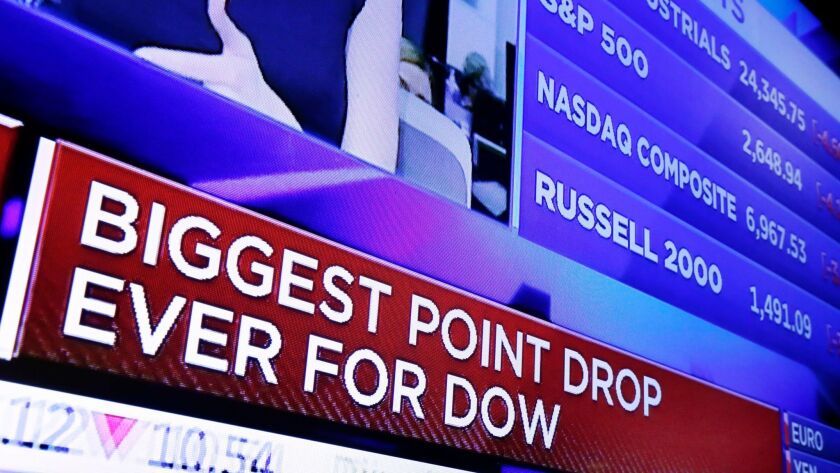 A TV screen on the floor of the New York Stock Exchange shows a headline with the stock index news at the close of trading Monday.
