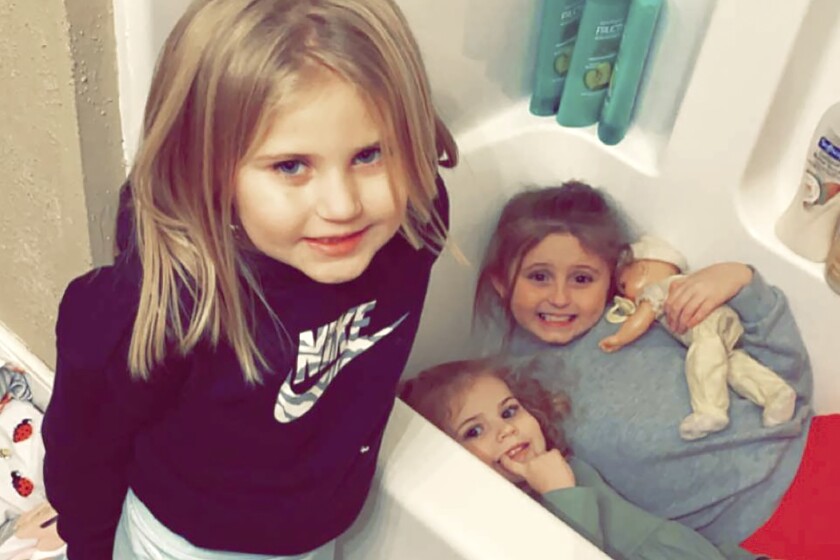 In this Dec. 10, 2021, photo provided by Sandra Hooker, from left, Avalinn Rackley, 7, Alanna Rackley, 3, and Annistyn Rackley, 9, pose for a picture in a bathroom in their home near Caruthersville, Missouri. Annistyn, a third-grader who loved swimming, dancing and cheerleading, was among dozens of people who died because of the severe storm on Friday, Dec. 10. A tornado hit her home and splintered it less than a week after the family had moved in, and, according to the relative who received the photo of the girl in the bathtub, it carried family members dozens of yards before dropping them in a muddy field. (Meghan Rackley/Courtesy of Sandra Hooker via AP)