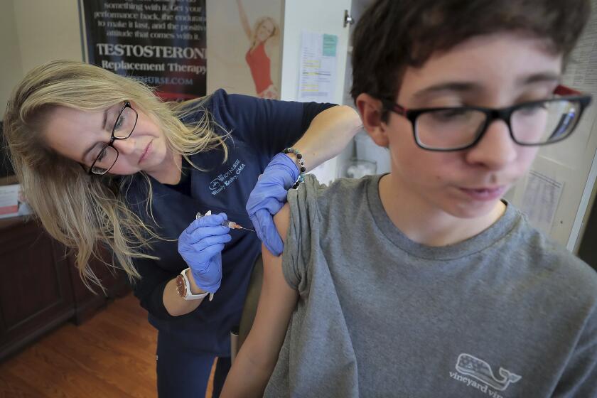 FILE - In this Jan. 3, 2019, file photo, Wendy Kerley gives Ethan Getman, 15, a shot of the flu vaccine at the Cordova Shot Nurse clinic in Memphis, Tenn. A second wave of flu is hitting the U.S., turning this into one of the nastiest flu seasons for children in a decade. (Jim Weber/Daily Memphian via AP, File)