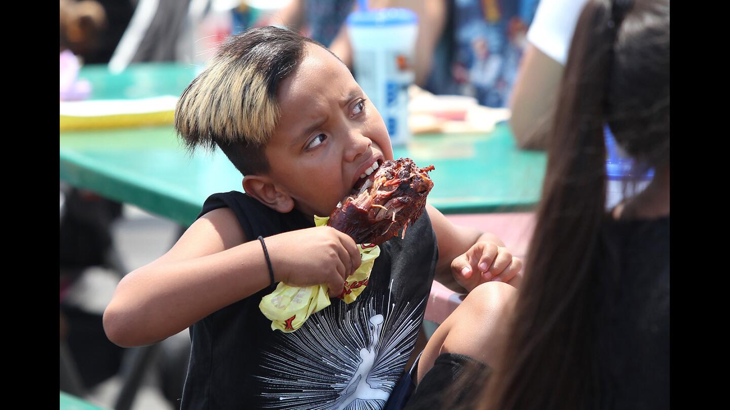 Frankie Reyes munches on a giant turkey leg, a longtime favorite fair food, at the OC Fair on Friday.