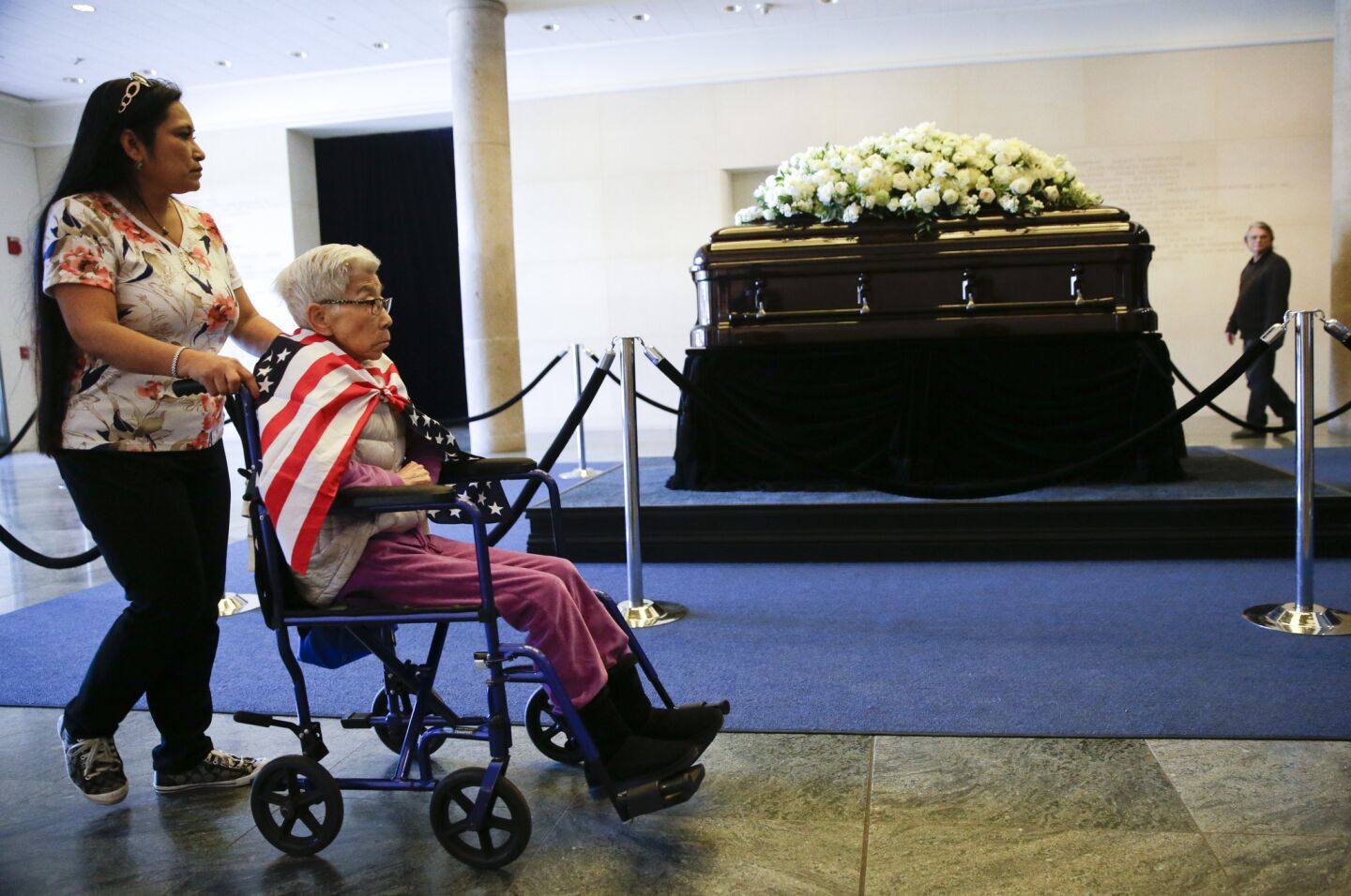 Stella Delgado, left, and her mother Yoko Santos pause as they pay their respects beside the casket of Nancy Reagan at the Ronald Reagan Presidential Library in Simi Valley, Calif.