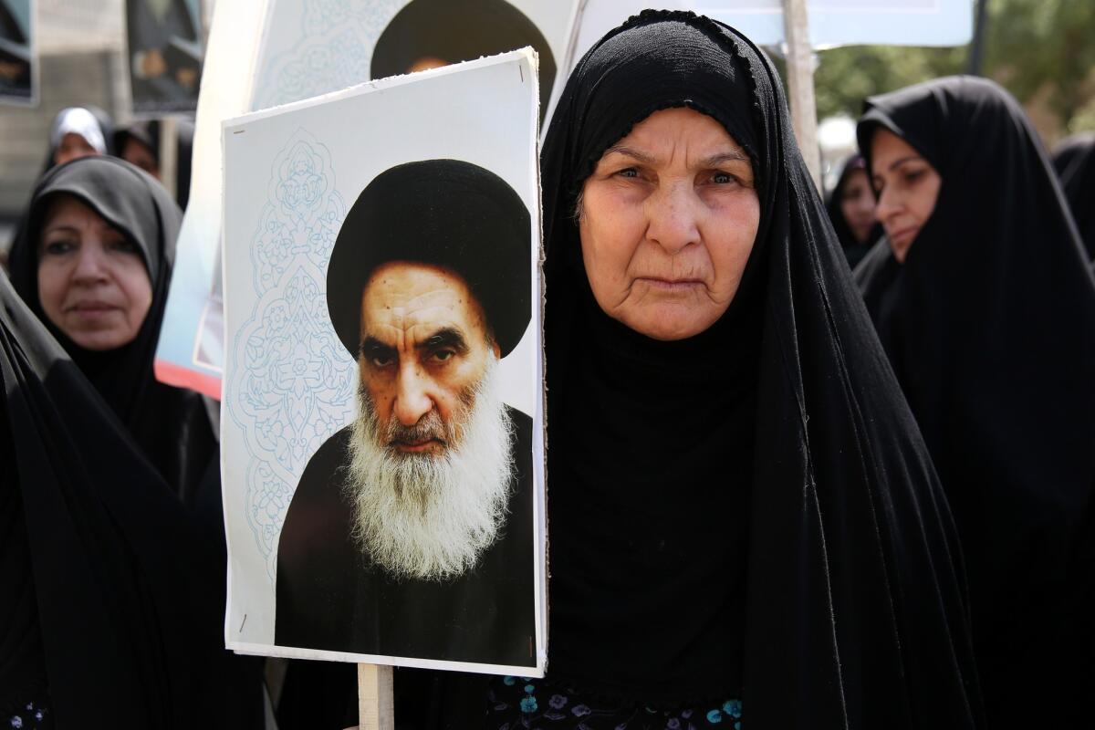 An Iraqi woman living in Iran holds a poster of Ayatollah Ali Sistani at a demonstration in Tehran against Iraqi insurgents.