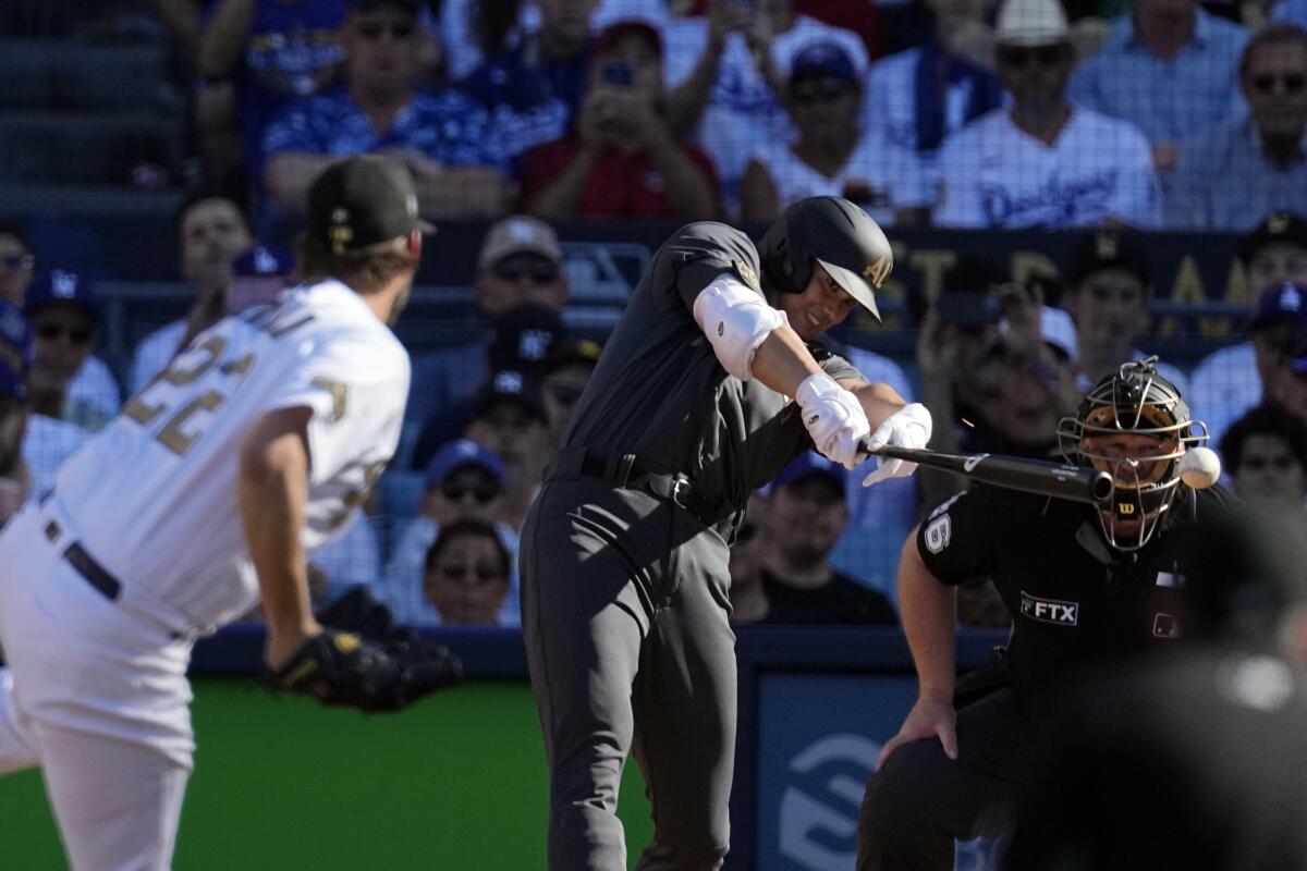 American League's Shohei Ohtani, of the Los Angeles Angels, right, singles of starting pitcher Clayton Kershaw, of the Los Angeles Dodgers, during the first inning of the MLB All-Star baseball game, Tuesday, July 19, 2022, in Los Angeles. (AP Photo/Jae C. Hong)