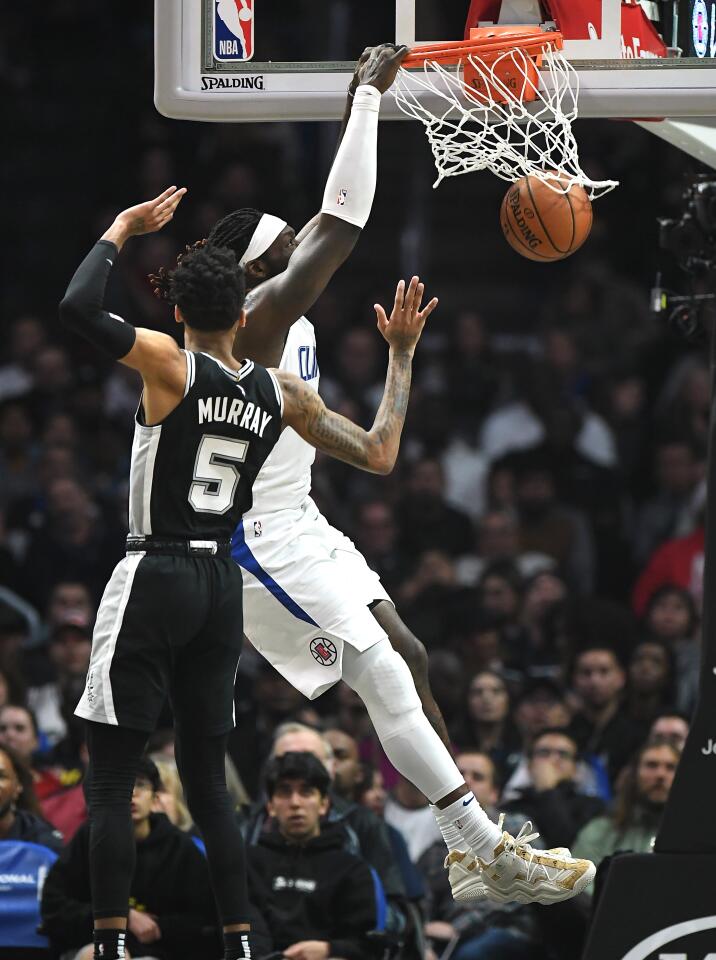Clippers forward Montrezl Harrell dunks over Spurs guard Dejounte Murray during the second quarter.