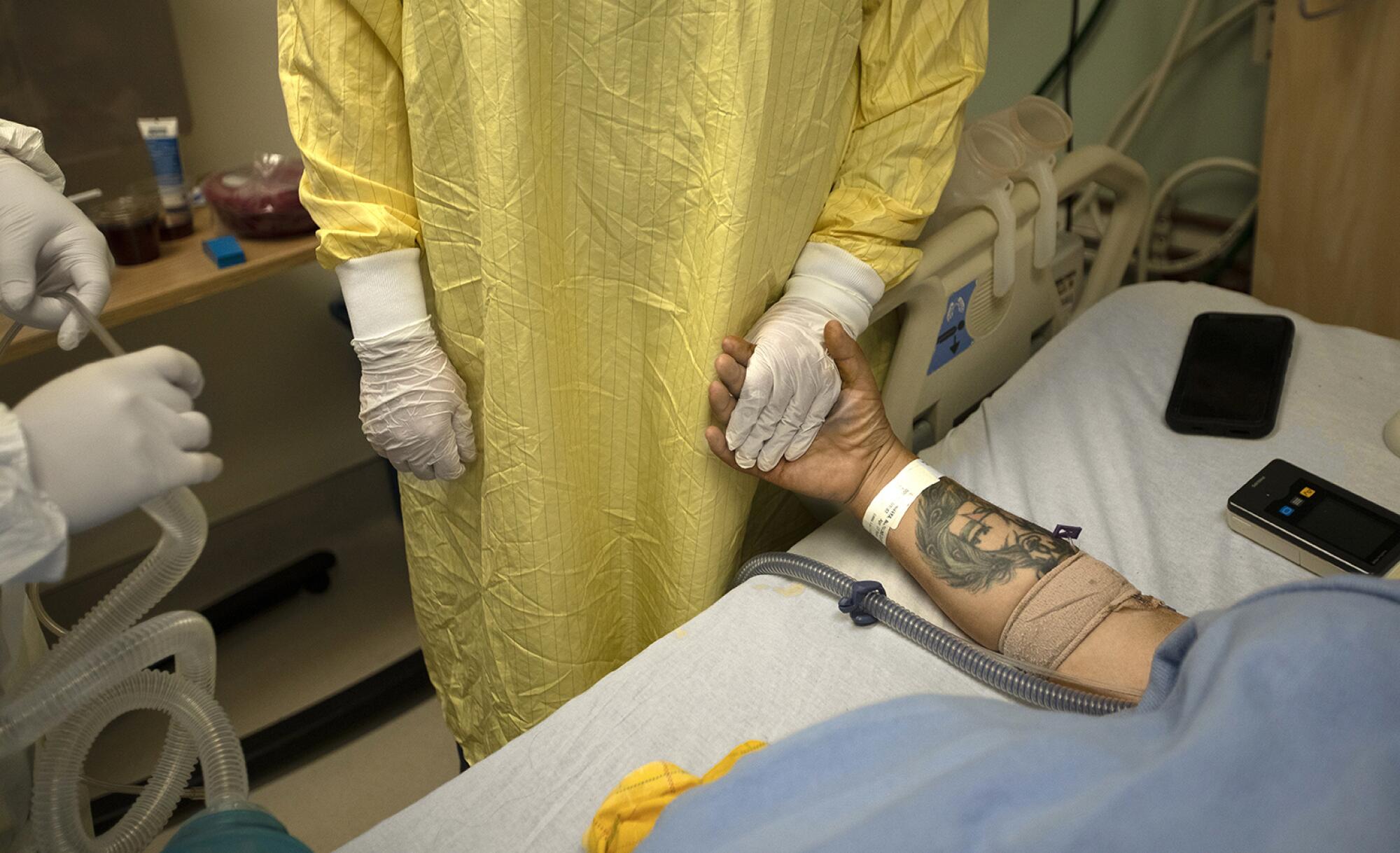 Nurse Jess Esperti holds Mariano Zuñiga Anaya's hand to relieve his anxiety about intubation.