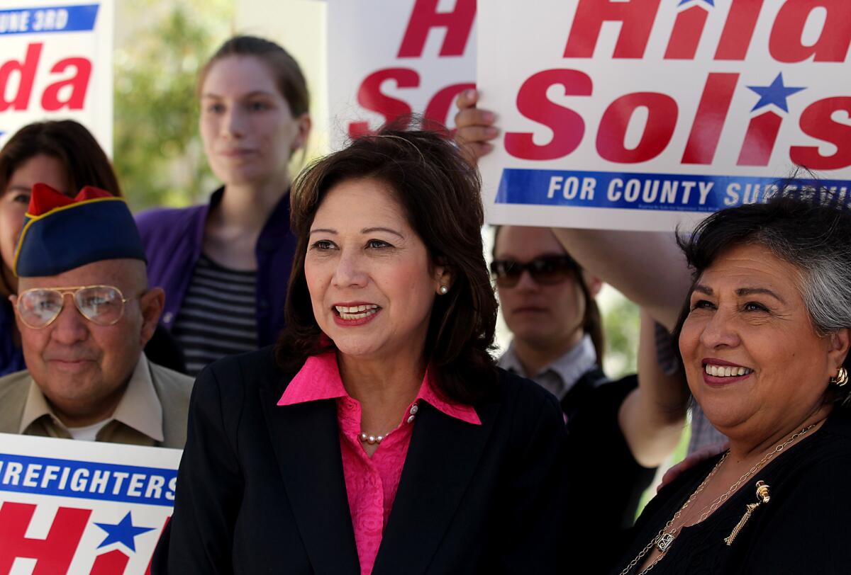 L.A. County supervisorial candidate Hilda Solis, center, is joined by supporters after getting the endorsement of Supervisor Gloria Molina, right, during a press conference at the Medical Village of the L.A. County/USC Medical Center in Los Angeles on Thursday