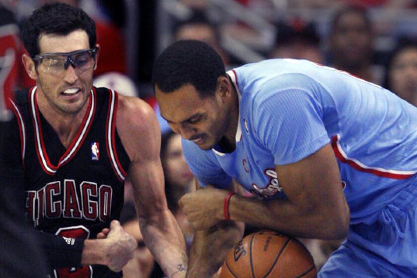 Clippers center Ryan Hollins, right, tries to keep the ball away from Chicago Bulls guard Kirk Hinrich during a game on Nov. 24.